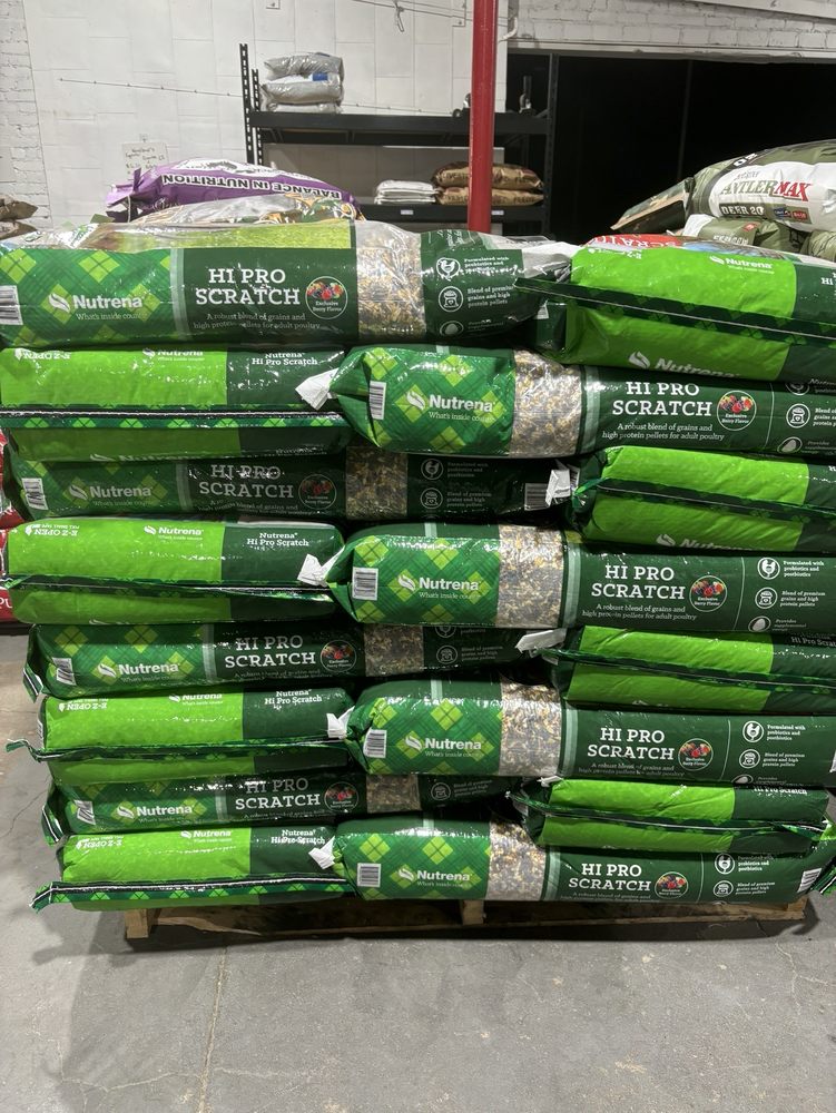 Green Nutrena Hi Pro Scratch bags for adult poultry stacked on a pallet