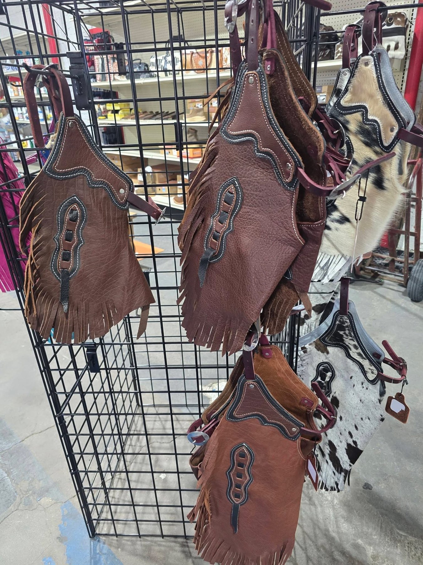 Kids leather and cowhide chaps on the western gear rack