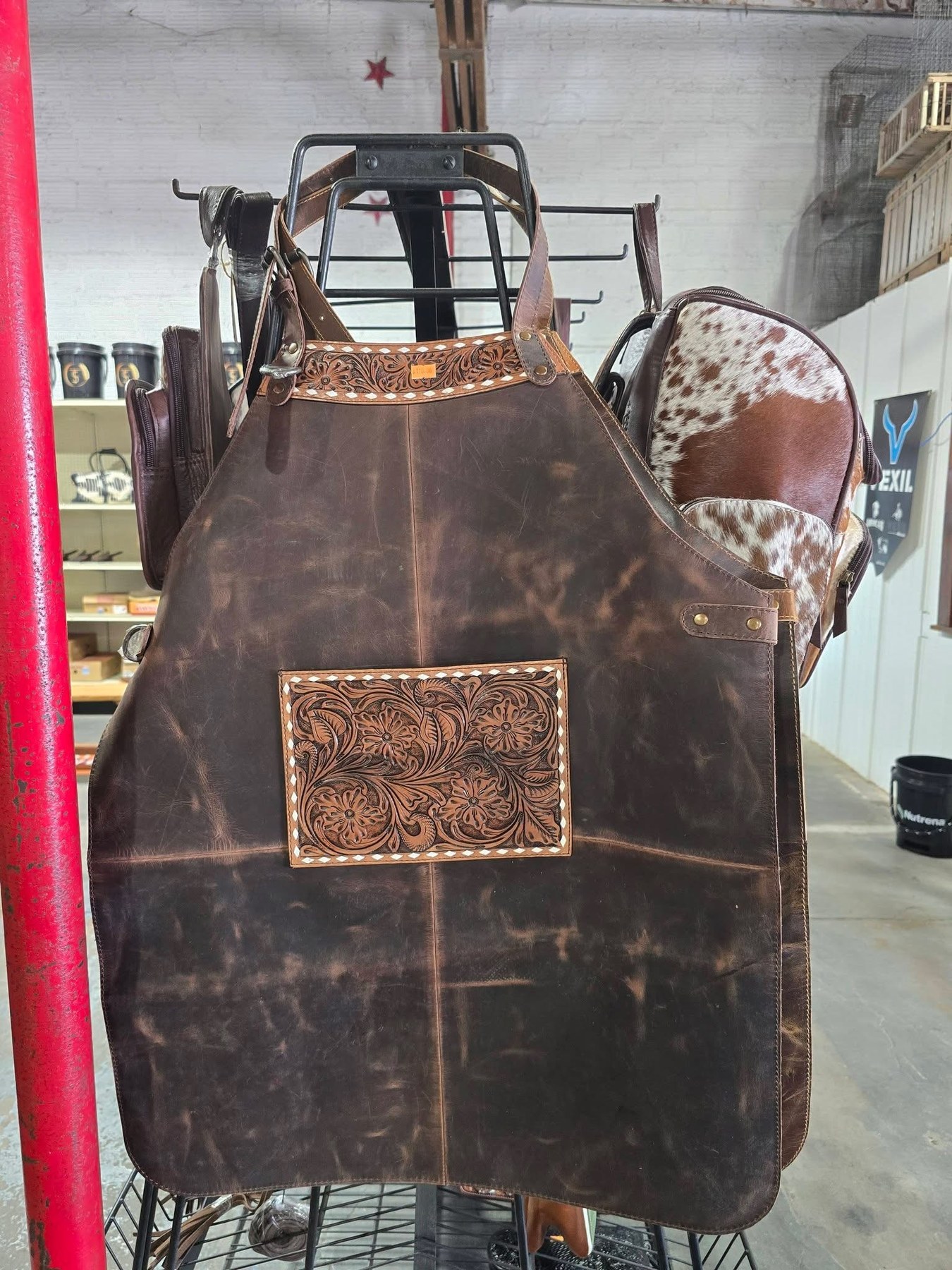 Tooled leather farrier and workshop apron hanging on the shop rack